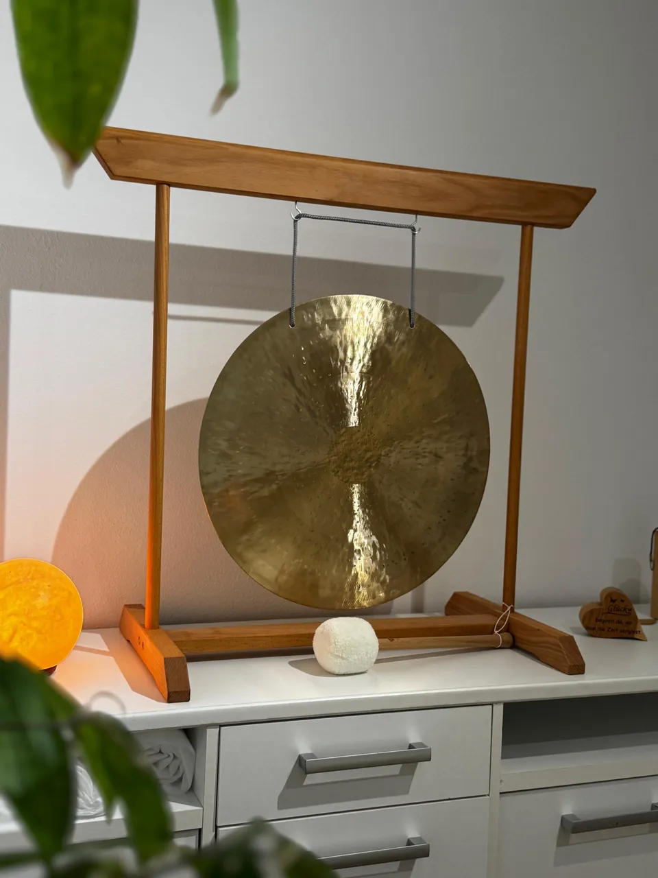 Gong im Holzrahmen auf einem Sideboard im Klangraum